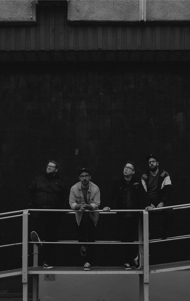 Punk rock band Have No Heroes members standing in front of a dark wall 